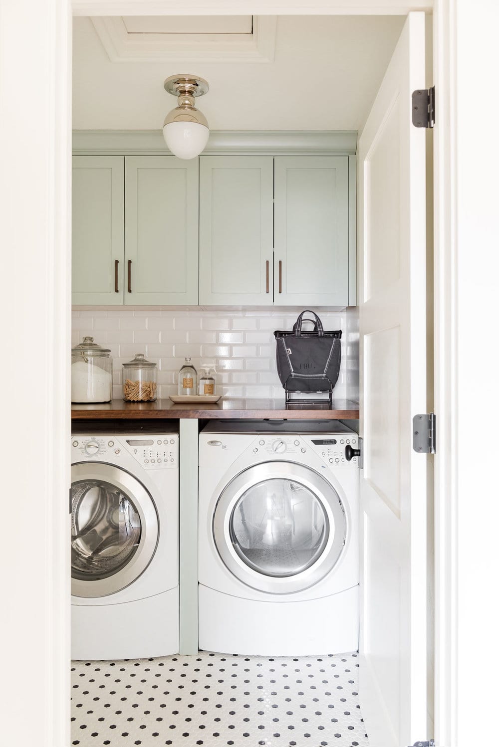 tile floors in laundry room with pastel cabinetry