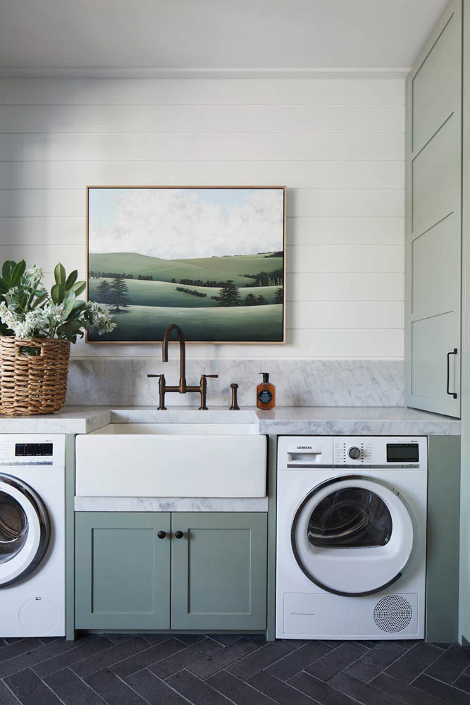 laundry room with art and green cabinetry